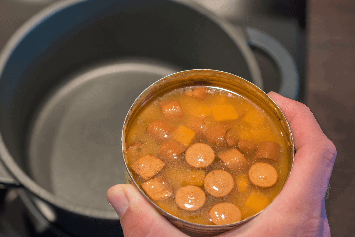 Unhealthy canned soup is heated in a pot