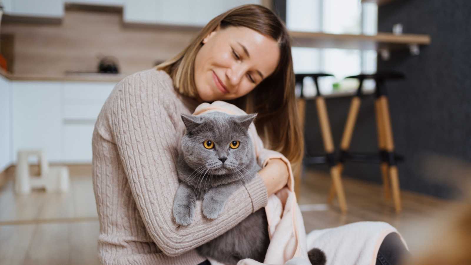 Woman cuddling with cat.